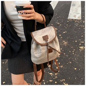 Vue détaillée du cordon de serrage et des bordures en cuir brun du sac à dos gris