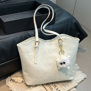 White tote bag with embossed floral patterns, long strap and cute plush charm detail
