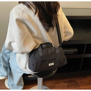 Detail of black nylon crossbody bag with JL FASHION label and metal zipper pocket