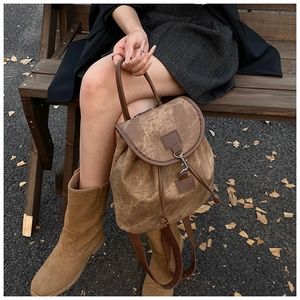 Détail du sac à dos vintage marron avec crochet métallique et finitions en cuir