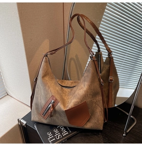 Detail view of khaki vintage hobo bag with brown leather strap and side zipper pocket