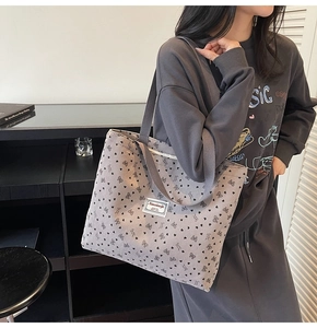 Detail of grey corduroy tote bag with black ribbon bows and heart polka dots