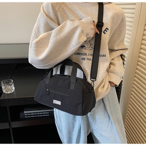 Detail of a black nylon crossbody Boston bag with JL Fashion label and top handles