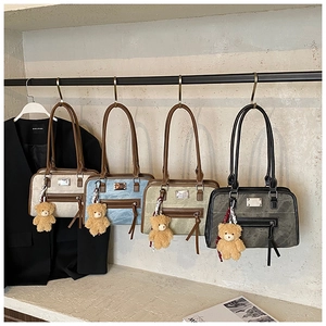 Gros plan de sacs cabas vintage en quatre couleurs avec pompons et breloques ours