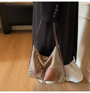 Detail of vintage brown canvas shoulder bag showing textured material and leather pockets