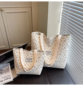 Detail of cream corduroy tote set featuring printed hearts, bows, and a fabric patch