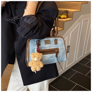 Détails du sac fourre-tout en jean bleu clair avec finitions en cuir marron et ours