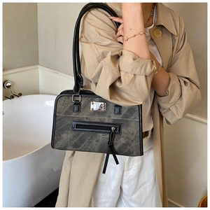 Détails d'un grand sac cabas vintage gris avec finitions en cuir noir et surpiqûres