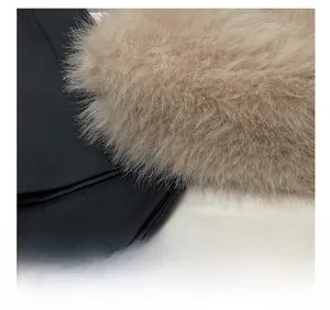Detailed close-up showing precision stitching on beige faux fur and black fabric joint