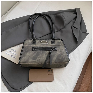 Détail d'un sac cabas rétro en cuir délavé avec long gland et plaque métallique de luxe