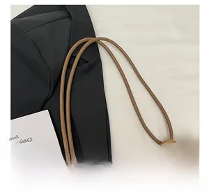 Detail of adjustable knotted brown leather strap on soft faux fur bucket bag