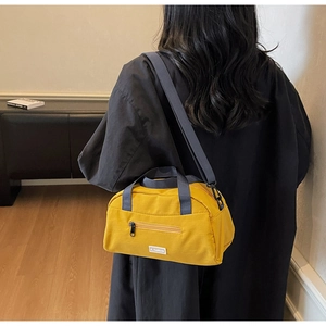 Detailed back view of a bright yellow nylon crossbody bag with adjustable straps
