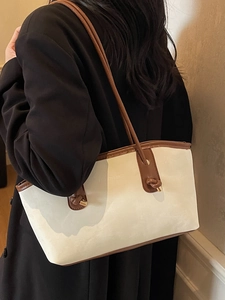 Large beige tote bag with brown leather straps shown on a model for daily commute