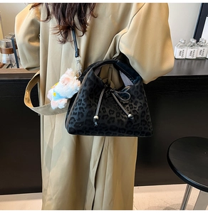 Detail of leopard print pillow bag with bow, plush texture and cute bear charm
