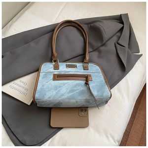 Détails macro du sac cabas en denim rétro avec lanières en cuir brun et finitions