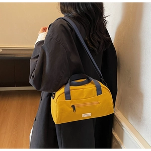 Detail of yellow nylon crossbody bag with blue straps and JL FASHION label on model