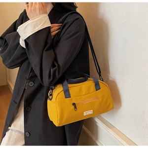 Detail of yellow nylon crossbody tote with JL FASHION logo and dark blue strap