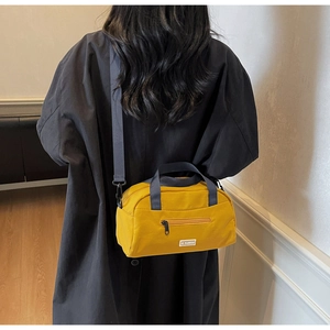 Bright yellow nylon crossbody tote bag shown on model for size and style comparison