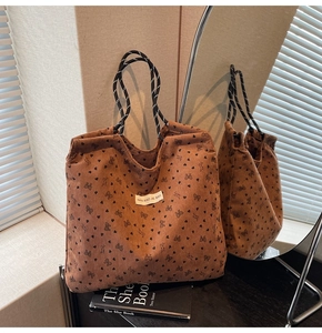 Detailed macro view of brown corduroy tote bag with heart patterns and woven rope handles