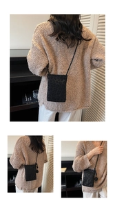 Close-up of black leopard print crossbody phone bag with matte texture and thin strap