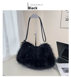 Detail of black fluffy faux fur bucket bag with leather strap and golden hardware