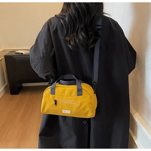 Close-up of yellow nylon crossbody bag featuring JL FASHION label and front zipper pocket