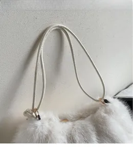 Détail du sac à bandoulière en fausse fourrure blanche avec fines lanières de cuir