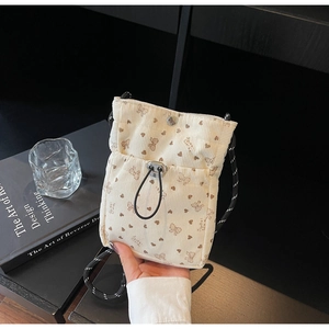 Detail of off-white corduroy crossbody phone bag with butterfly print and drawstring