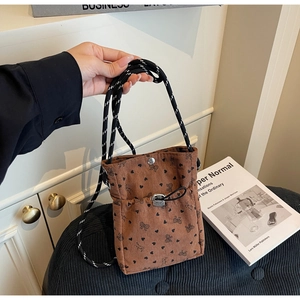Brown corduroy crossbody bag featuring heart and bow patterns with rope strap details