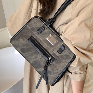 Sac cabas rétro gris avec surpiqûres contrastées et bordures en cuir, vue latérale