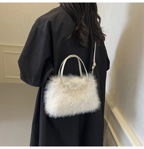 Detailed view of white faux fur tote bag showing plush texture and gold metal attachments