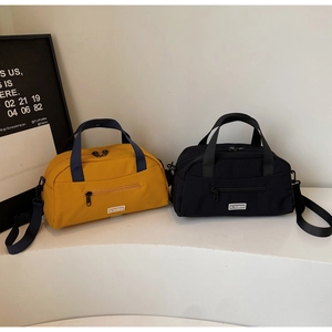 Macro detail of yellow and black nylon tote bags with adjustable straps and logo tags