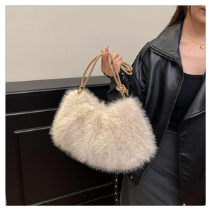Detail of plush faux fur bucket bag in apricot with leather strap and gold hardware