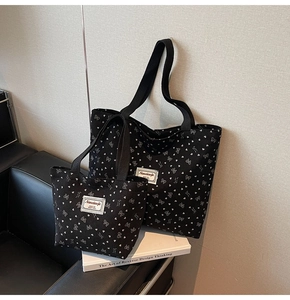 Detail of black canvas tote set featuring white heart and bow prints with fabric labels