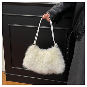 Detail of soft white faux fur bucket bag with golden metal rings and slim PU shoulder strap