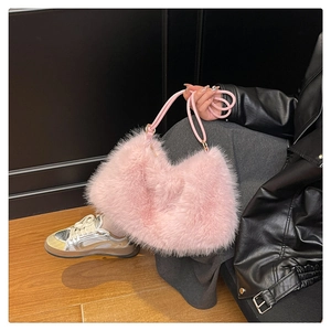 Close-up of a plush pink bucket bag featuring soft faux fur texture and a leather strap