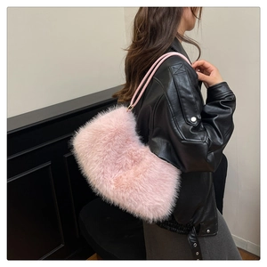 Detail of pink faux fur bucket bag with soft plush texture and slim leather strap