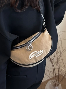 Lightweight khaki crescent chest bag with adjustable strap worn by a model