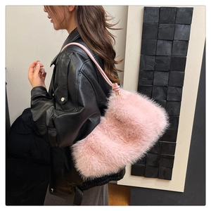 Detail of pink faux fur bucket bag featuring golden hardware and fluffy texture detail