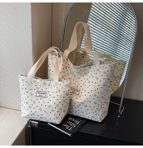 Detail of canvas tote bag set with heart and bow patterns in a lifestyle setting