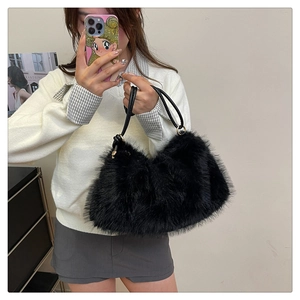 Close-up of fluffy black faux fur bucket bag with knotted leather shoulder strap details