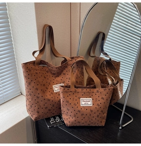 Detailed close-up of brown corduroy tote bags with heart and bow patterns in a room set
