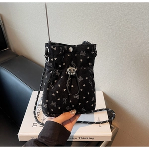 Detail of black corduroy phone bag showing pleated texture and white butterfly pattern