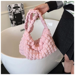 Detail showing the pink bubble texture and pleated fabric of the large shoulder bag