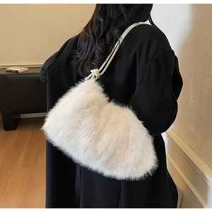 Détail d'un sac à épaule en fausse fourrure blanche sur un manteau en laine noir