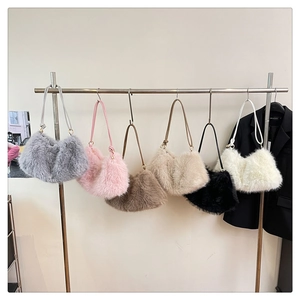 Detail view of large plush bucket bags in six colors hanging on a display rack