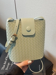 Chic light green woven leather bucket bag with magnetic flap and golden metal hardware