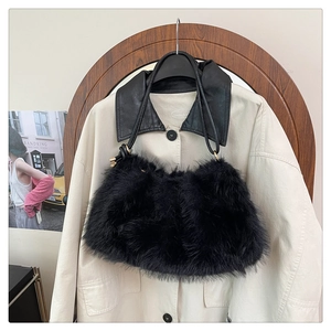 Detail of a plush black faux fur bucket bag with thin leather straps and gold hardware