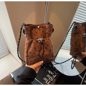 Detailed texture of brown corduroy crossbody bag with cute heart and bow patterns