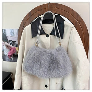 Detail of grey faux fur bucket bag with plush texture and golden metal hardware